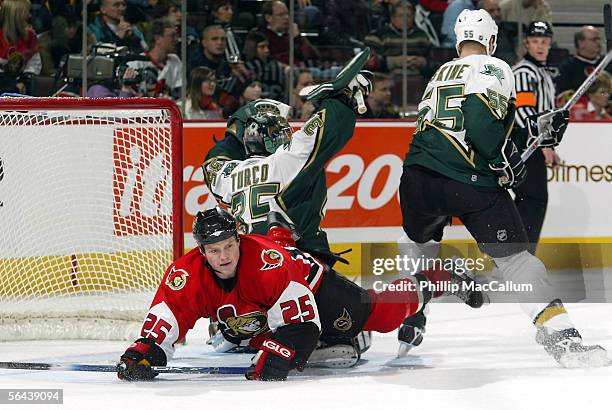 Chris Neil of the Ottawa Senators trips over goalie Marty Turco of the Dallas Stars on December 15, 2005 at the Corel Centre in Ottawa, Ontario,...