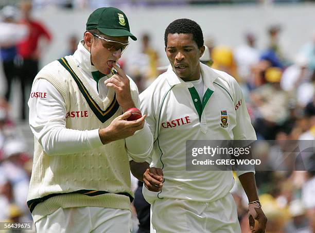 South African captain Graeme Smith talks with his bowler Makhaya Ntini on day one of the first Test against Australia in Perth, 16 December 2005....