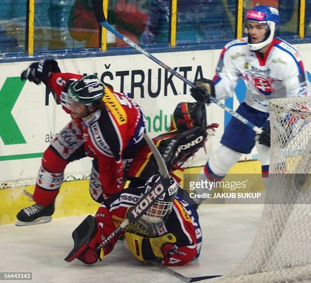 Switzerland's goalie Marco Buhrer saves a puck and falls down along with Severin Blindenbacher after an attack by Slovakian Radovan Somik during the...
