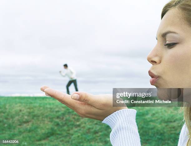 man standing on woman's hand, optical illusion - perspective artificielle photos et images de collection