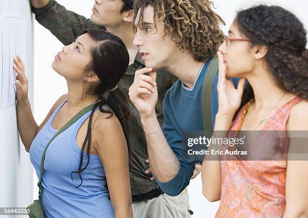 students looking at results posted on wall, side view - baccalaureat stock pictures, royalty-free photos & images