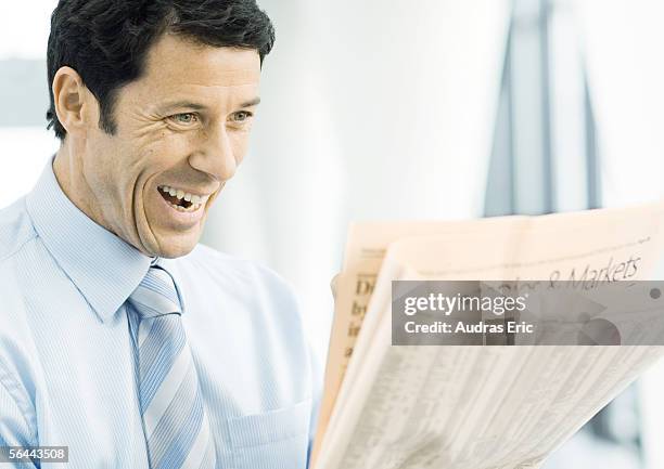 businessman looking at newspaper excitedly - shareholder stock pictures, royalty-free photos & images