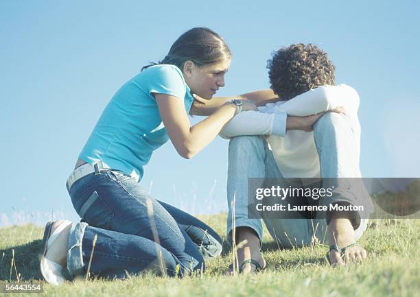 teenage couple, girl trying to talk to boy with head down - friendship breakup stock pictures, royalty-free photos & images