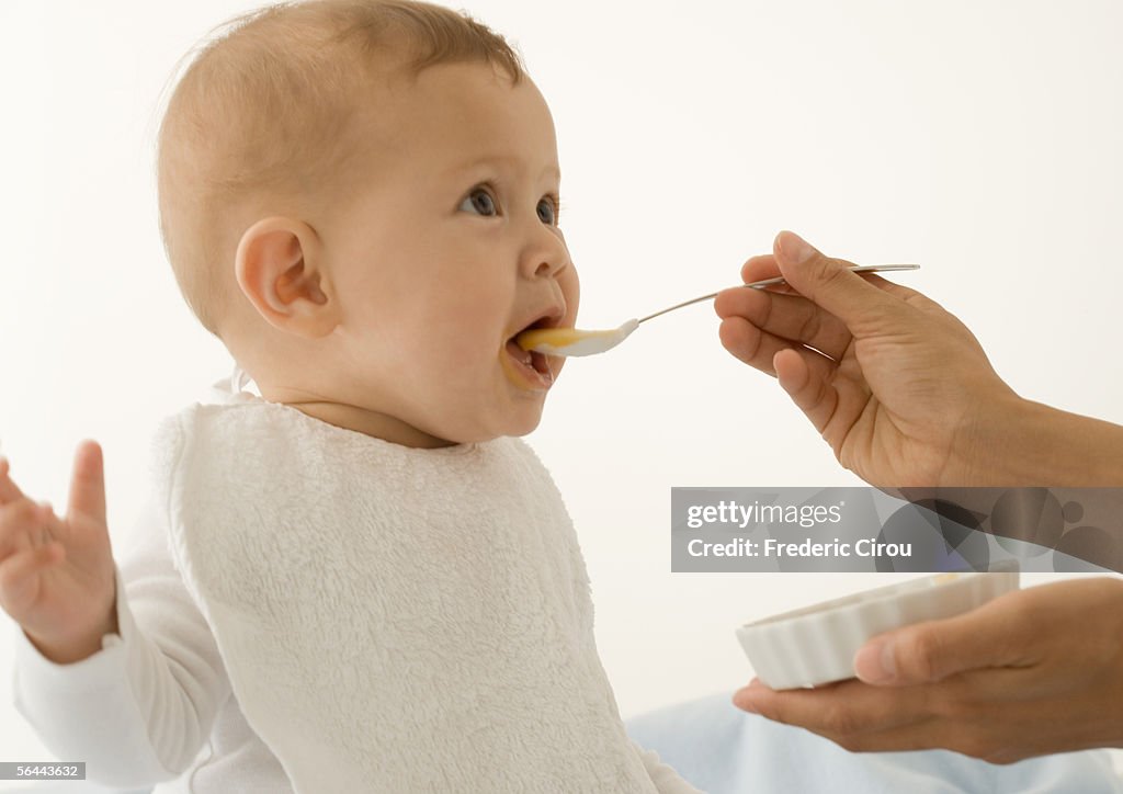 Baby being fed baby food