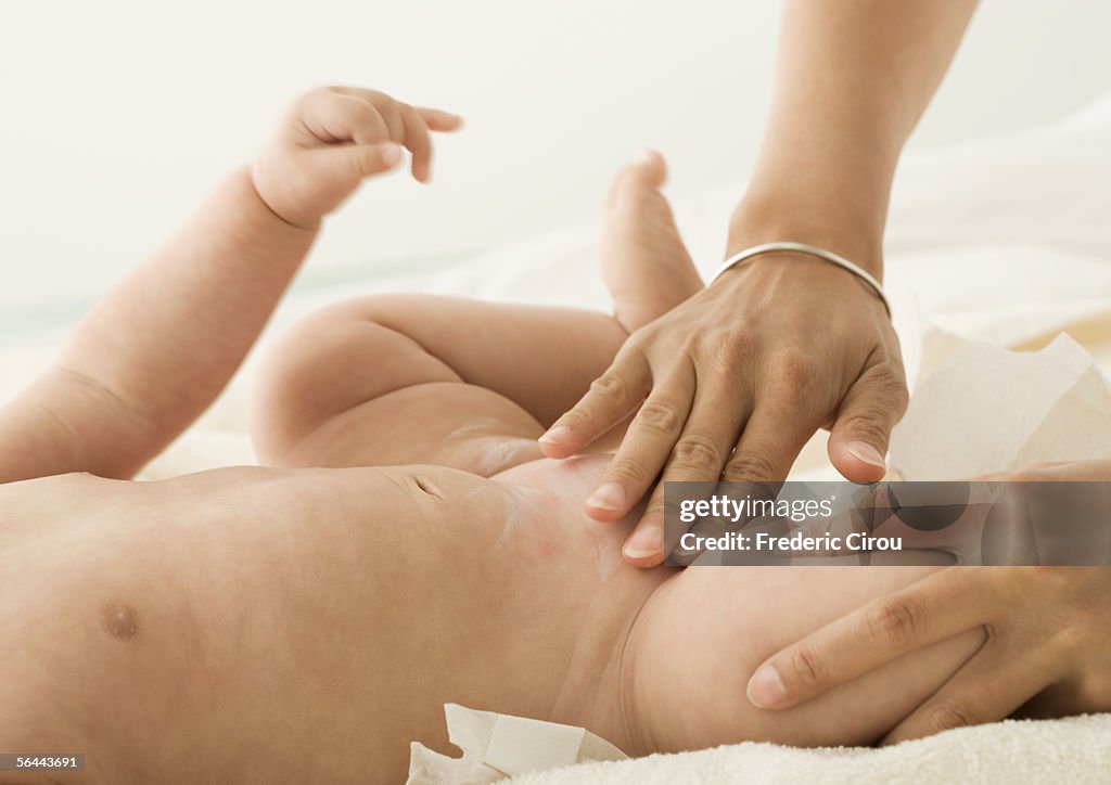 Baby having cream applied to diaper area