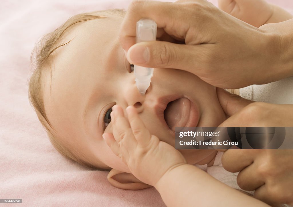 Baby having nose cleaned