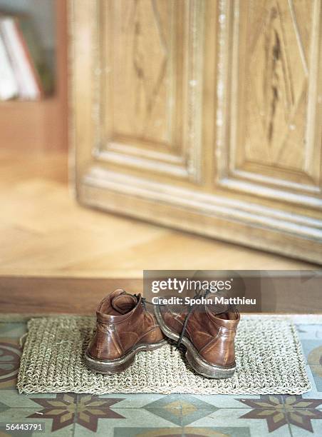 shoes on doormat - door mat stock-fotos und bilder