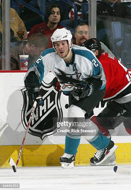 Scott Hannan of the San Jose Sharks pushes a backhand pass during their NHL game against the Buffalo Sabres on December 2, 2005 at HSBC Arena in...