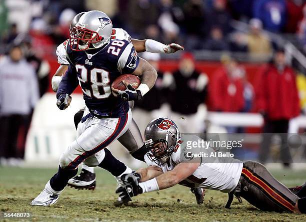 Corey Dillon of the New England Patriots eludes the tackle of Barrett Ruud of the Tampa Bay Buccaneers on December 17, 2005 at Gillette Stadium in...