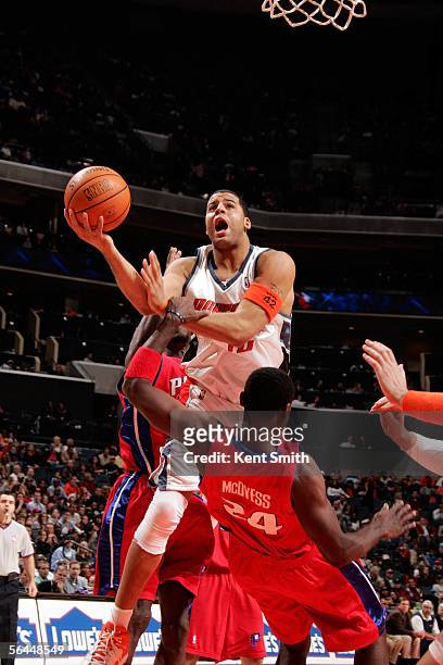 Sean May of the Charlotte Bobcats shoots over Antonio McDyess of the Detroit Pistons on December 17, 2005 at the Bobcats Arena in Charlotte, North...