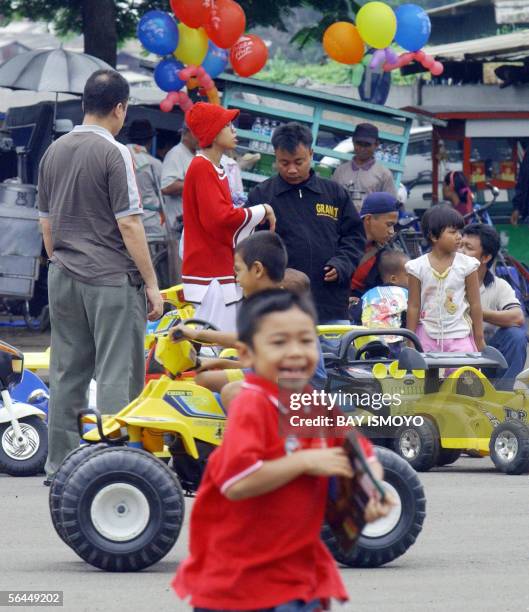 Indonesian children from middle-low class family, drive 30 cent rent electric car at a public park in Jakarta 18 December 2005. Children experience...