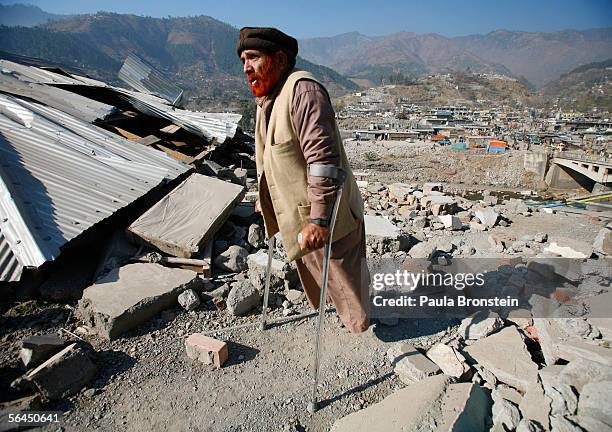 Handicapped earthquake survivor walks among the rubble December 17, 2005 in the town of Balakot, Pakistan. Lack of snow is giving the quake survivors...