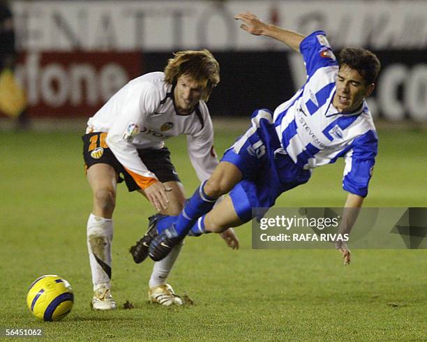 Alaves' Carpintero is tackled by Valencia's Mista, 18 December 2005 during a Spanish league football match at the Mendizorroza stadium in Vitoria....