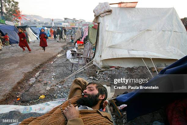 Mohammed Fez rests in a bed by his tent recovering from a fractured hip and leg in a small tent camp on December 18, 2005 in Muzaffarabad, Pakistan....