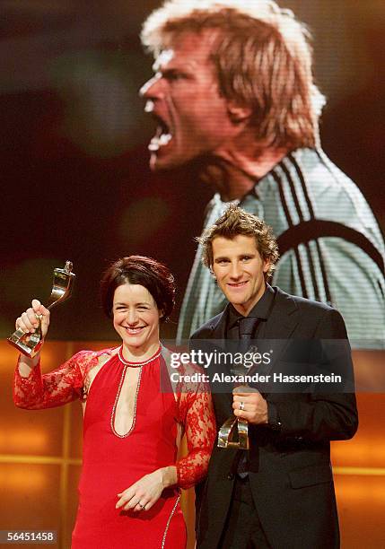 Uschi Disl holds her 'Sportswoman of the Year 2005' Award together with Ronny Ackermann , winner of the 'Sportsman of the Year 2005' Award whilst a...