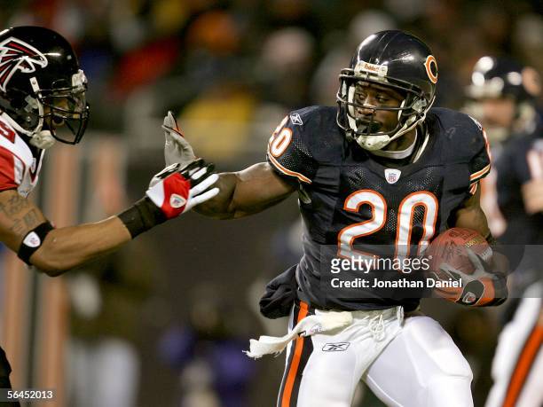Thomas Jones of the Chicago Bears stiff arms Michael Boley of the Atlanta Falcons during a game on December 18, 2005 at Soldier Field in Chicago,...