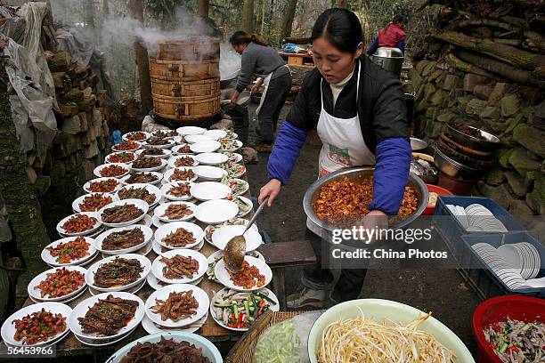 Chinese women prepare dishes for the "Nine Big Bowls" feast to celebrate a villager's baby becoming a month old in a village December 18, 2005 in...