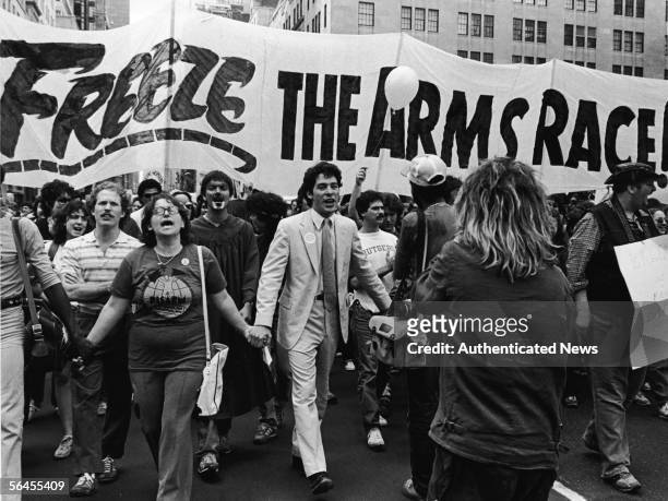 Demonstrators hold hands and vocalize as they march towards Central Park during a massive nuclear disarmament rally where 750,000 gathered to demand...