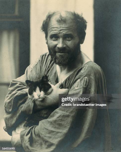 Gustav Klimt, in his arms holding one of his cats , in front of his studio in Vienna, 8th district, Josefstaedter Strasse 21. Photography by Moriz...