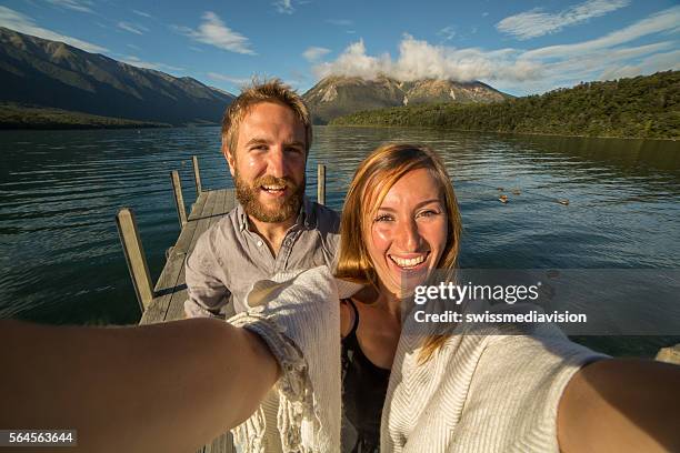 couple takes selfie portrait on lake pier - nelson lakes national park stock pictures, royalty-free photos & images