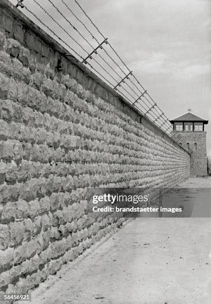 Concentration camp Mauthausen: watchtower and stone wall with barbed wire. Photography, around 1940. [Konzentrationslager Mauthausen: Wachtturm und...