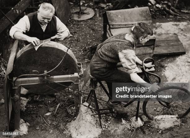 Technological progress: Grinding stone driving per bicycle. England. Photography, 1938. [Technologischer Fortschritt: Ein englischer Schmied laesst...