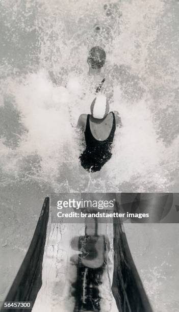 Water slide in the Tottenham Lido in London. Photography, 1937. [Im Schwimmbad Tottemham Lido in London: Auf der Wasserrutsche. Photographie, 1937.]