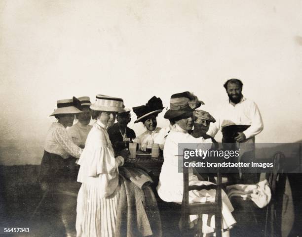 Gustav Klimt sitting at a table with his friends on a trip to the Gahberg at the Attersee lake. Photography, 1908. [Gustav Klimt mit Freundesrunde...