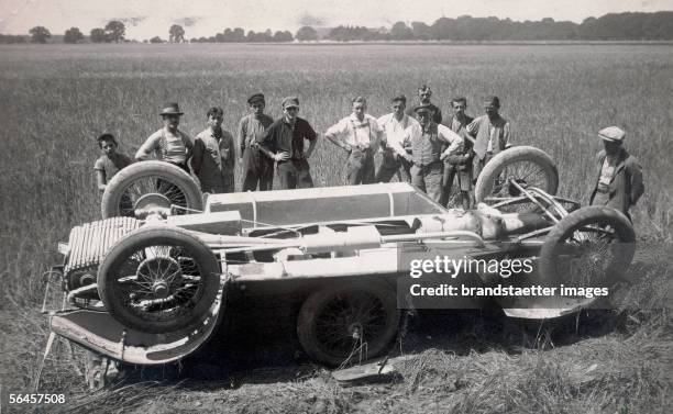 Car accident near Ranshofen, 22nd of July, 1925. Photography. [Nach einem Autounfall: Eine Limousine liegt, die Raeder nach oben, von Zuschauern...