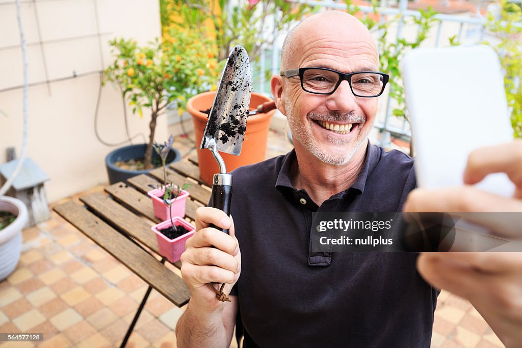 Adult man planting tomatoes on his balcony