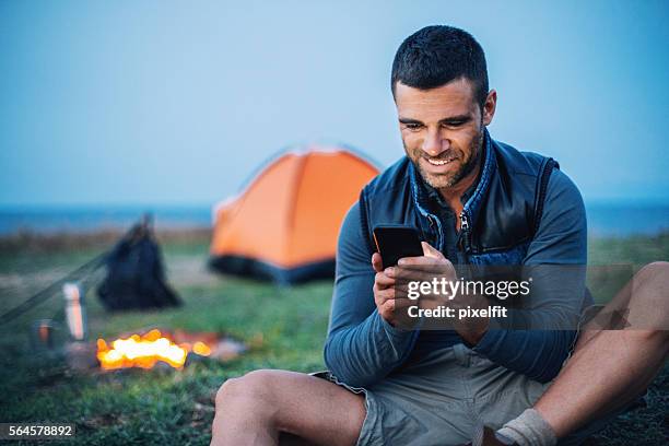 communication in the mountain camp - young men camping stock pictures, royalty-free photos & images