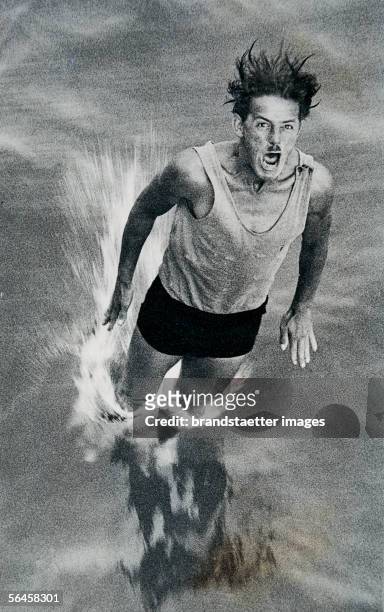 Man with moustache and bathing suit dipping into the water. Photography, around 1930. [Mann mit Oberlippenbart und Ganzbadetrikot im Sprung beim...