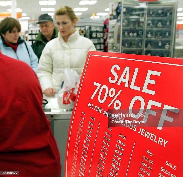 Shoppers are seen beyond a sale sign at the jewelry counter in a Kmart store December 19, 2005 in Norridge, Illinois. Consumers are visiting stores...