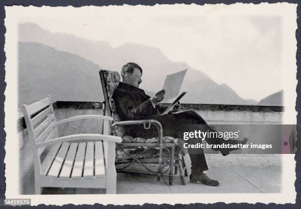 The Berghof of Adolf Hitler at the Obersalzberg near Berchtesgaden: Adolf Hitler at the patio of the Berghof, wearing civil clothes, sitting in a...