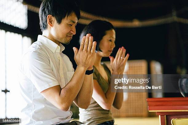 pareja japonesa rezando en un templo budista - shrine fotografías e imágenes de stock