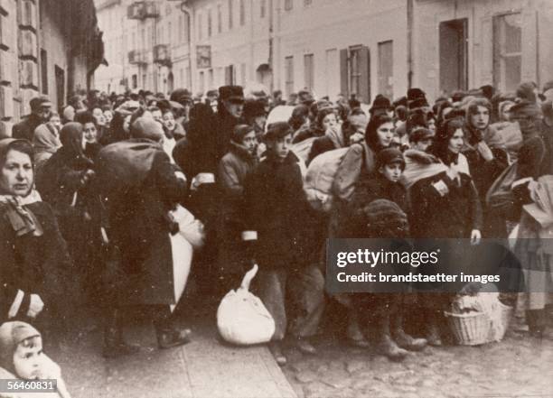 Holocaust: Jews waiting on a Warsaw street for the deportation to a concentration camp. Poland. Photography. About 1944. [Holocaust: Warten von Juden...