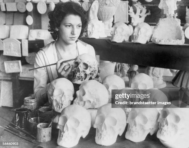 Girl painting malleable models of human skulls for medical research reasons. Los Angeles. 1932. [Maedchen beim Bemalen plastischer Modelle...