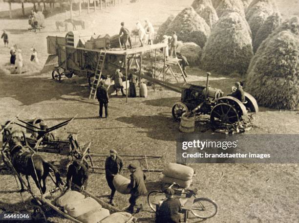 Crop threshing in the kolkhoz Kultivator in the Sovjet Union. Picture from the picture archive Oesow, Vienna. Photography. About 1930. [Das Dreschen...