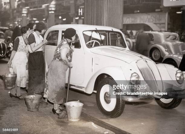 Charladies examining a luxury limousine at an automobile exhibition in London 1936. Photography. 1936. [Putzfrauen begutachten eine Luxus-Limousine...