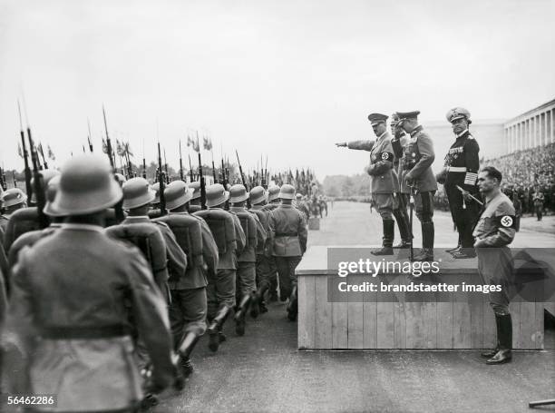 Adolf Hitler at a parade of the "Wehrmacht" . Next to him: General field marshal Werner von Blomberg, general colonel Hermann Goering and general...