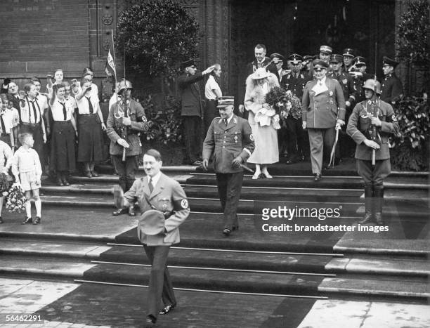 Hermann Goering and Emmy Sonnemann leave the registry office after their marriage. The witnesses to the marriage Adolf Hitler and Hans Kerrl are...