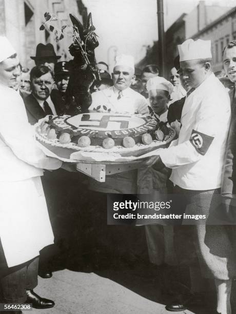 Confectioner from Berlin holding a birthdaycake with swastika for Adolf Hitler. Berlin. Germany. Photography. 20.4.1935. [Ein Berliner Konditor mit...