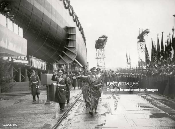 Adolf Hitler is attending a shiplaunch in Wilhelmshaven. Also present: Grand Admiral Erich Raeder and Field marshal Werner von Blomberg. Photography....