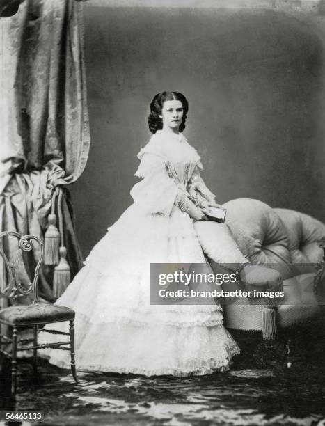 Empress Elisabeth from Austria . Whole figure standing, half right; white dress, opened book in her hands. Photograph by Ludwig Angerer, later fall...