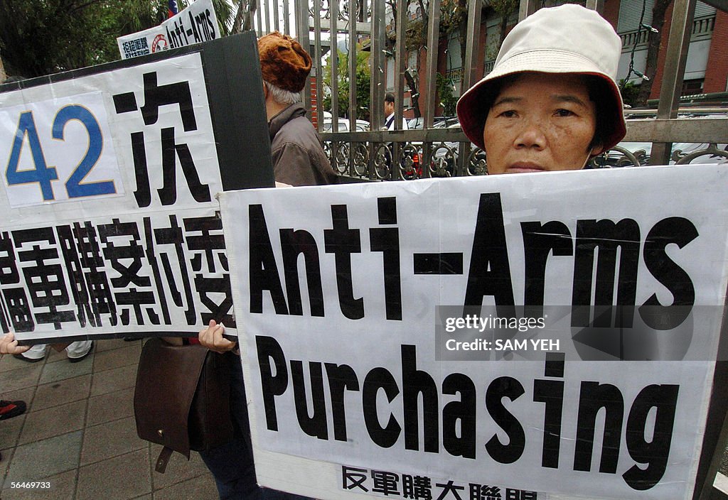 Protesters display placards during a demonstration outside the... News ...