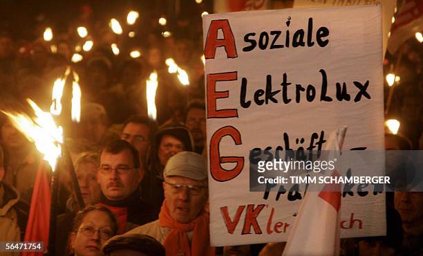 Employees of AEG, a brand of Swedish maker of electrical household appliances Electrolux, gather with torches to protest against the planned closure...