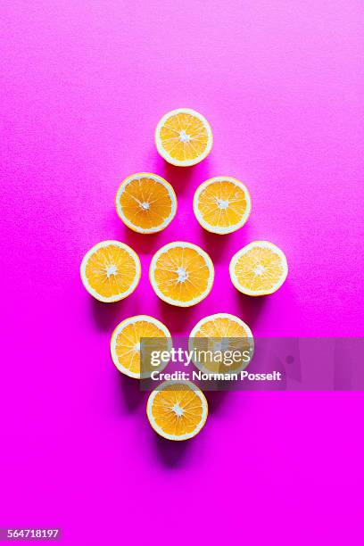 Directly above shot of orange slices arranged in diamond shape on pink background