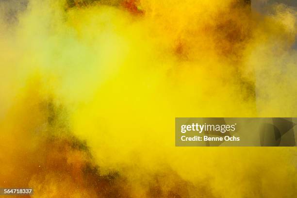 yellow powder paint spraying during holi festival - powder paint stock pictures, royalty-free photos & images