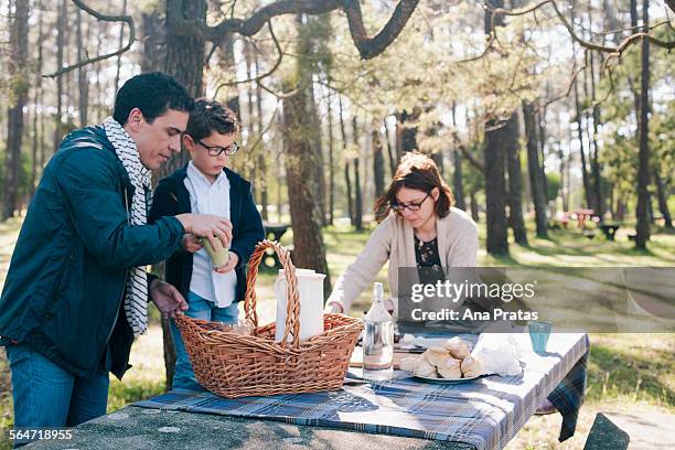 family preparing for breakfast in forest - picnic table stock pictures, royalty-free photos & images