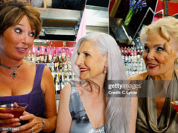 three senior women having cocktails at a bar - cougar women stock-fotos und bilder